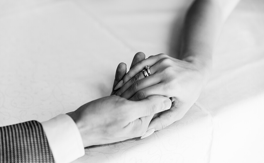 twee handen die elkaar vasthouden met een trouwring